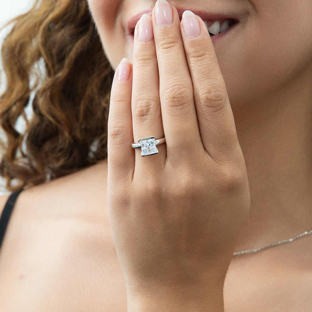 Model wearing Solitaire 2ct Bezel Princess CZ Ring in Sterling Silver, 2 of 9