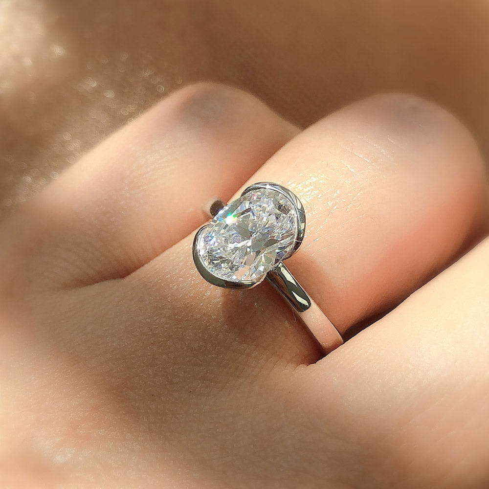Model wearing Solitaire 1.8ct Bezel Oval CZ Ring in Sterling Silver, 2 of 9