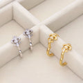 Flatlay view of Fleur De Lis CZ Mini Huggie Earrings in Sterling Silver 0.5 inch