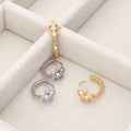 Flatlay view of Fleur De Lis CZ Mini Huggie Earrings in Sterling Silver 0.5 inch