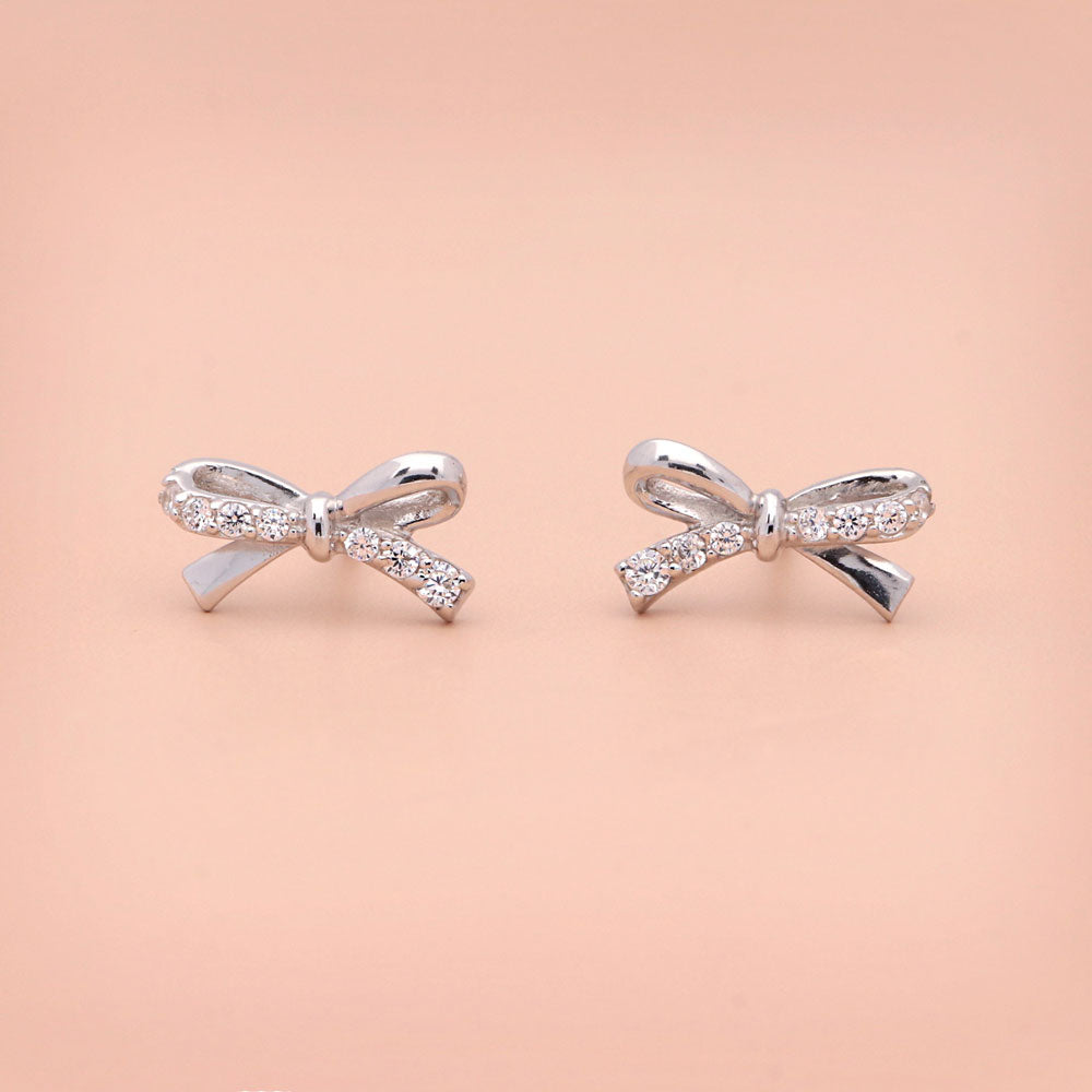 Flatlay view of Bow Tie Ribbon CZ Cartilage Stud Earrings in Sterling Silver, 4 of 6