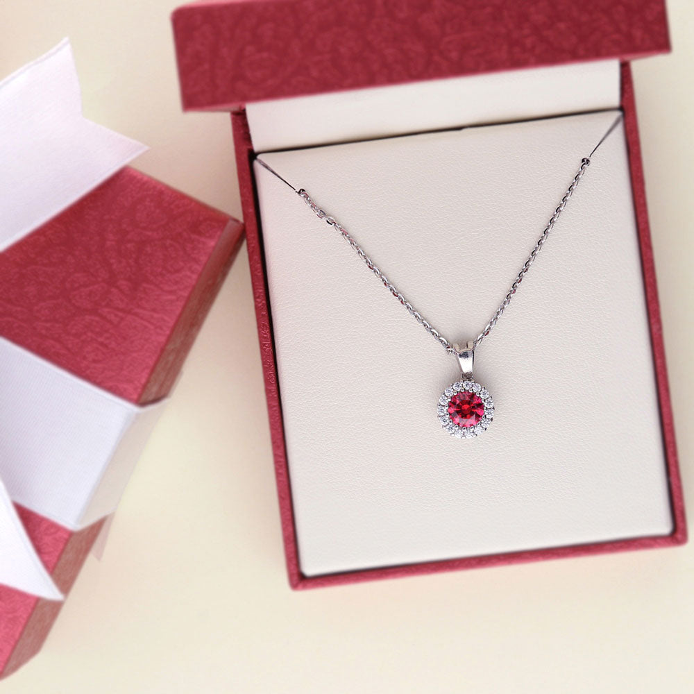 Flatlay view of Halo Red Round CZ Necklace and Earrings Set in Sterling Silver