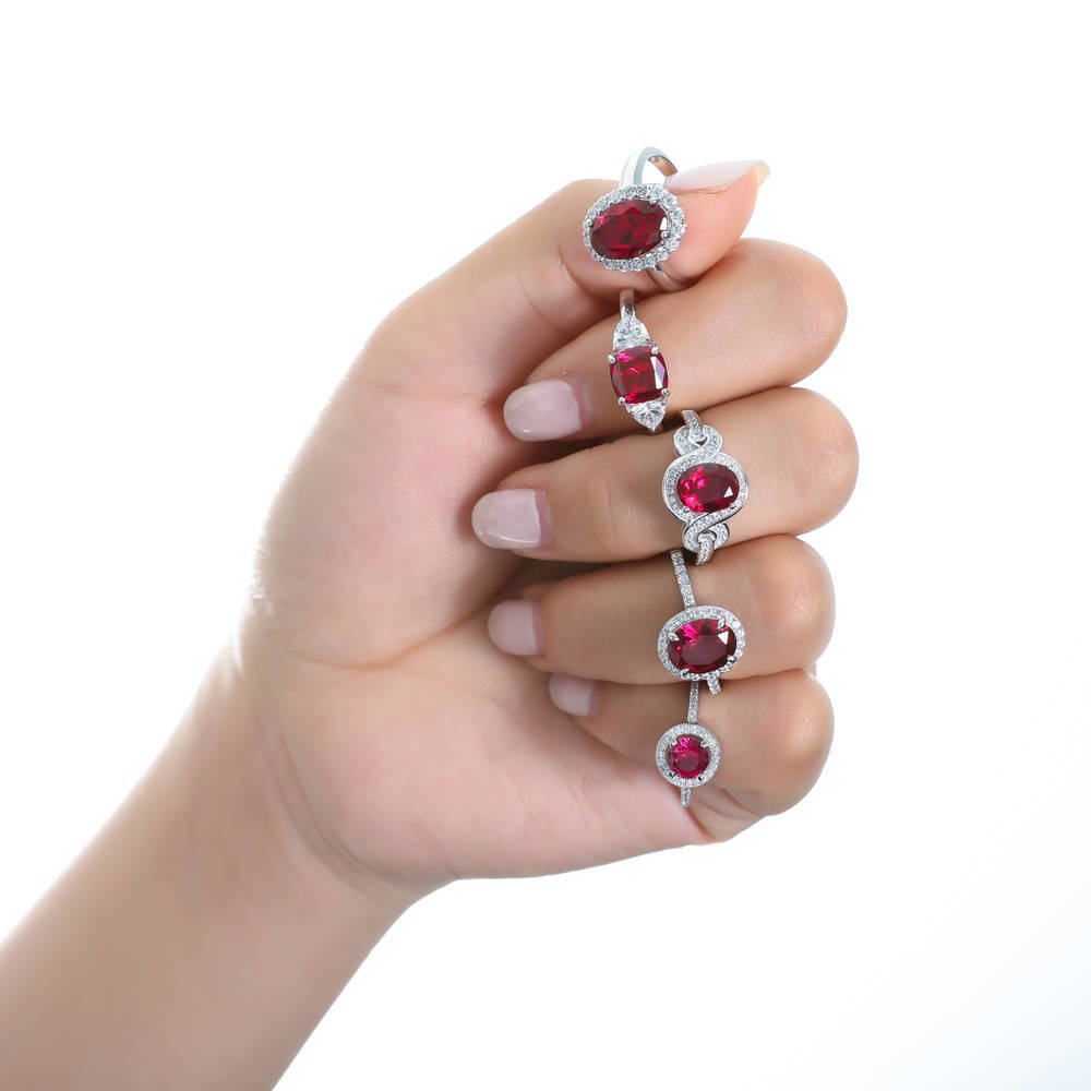 Model wearing 3-Stone 3ct Simulated Ruby Cushion CZ Ring in Sterling Silver, 9 of 10