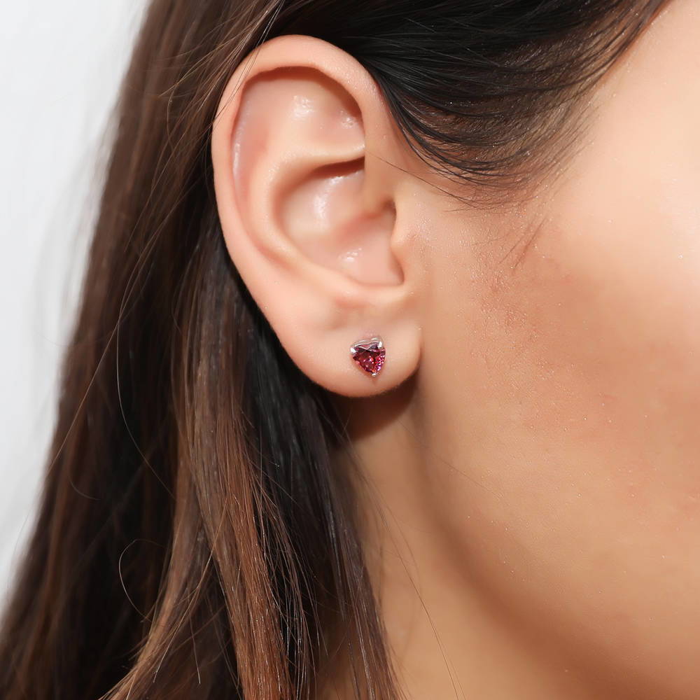 Model wearing Solitaire Heart Red Heart CZ Stud Earrings in Sterling Silver, 2 of 5