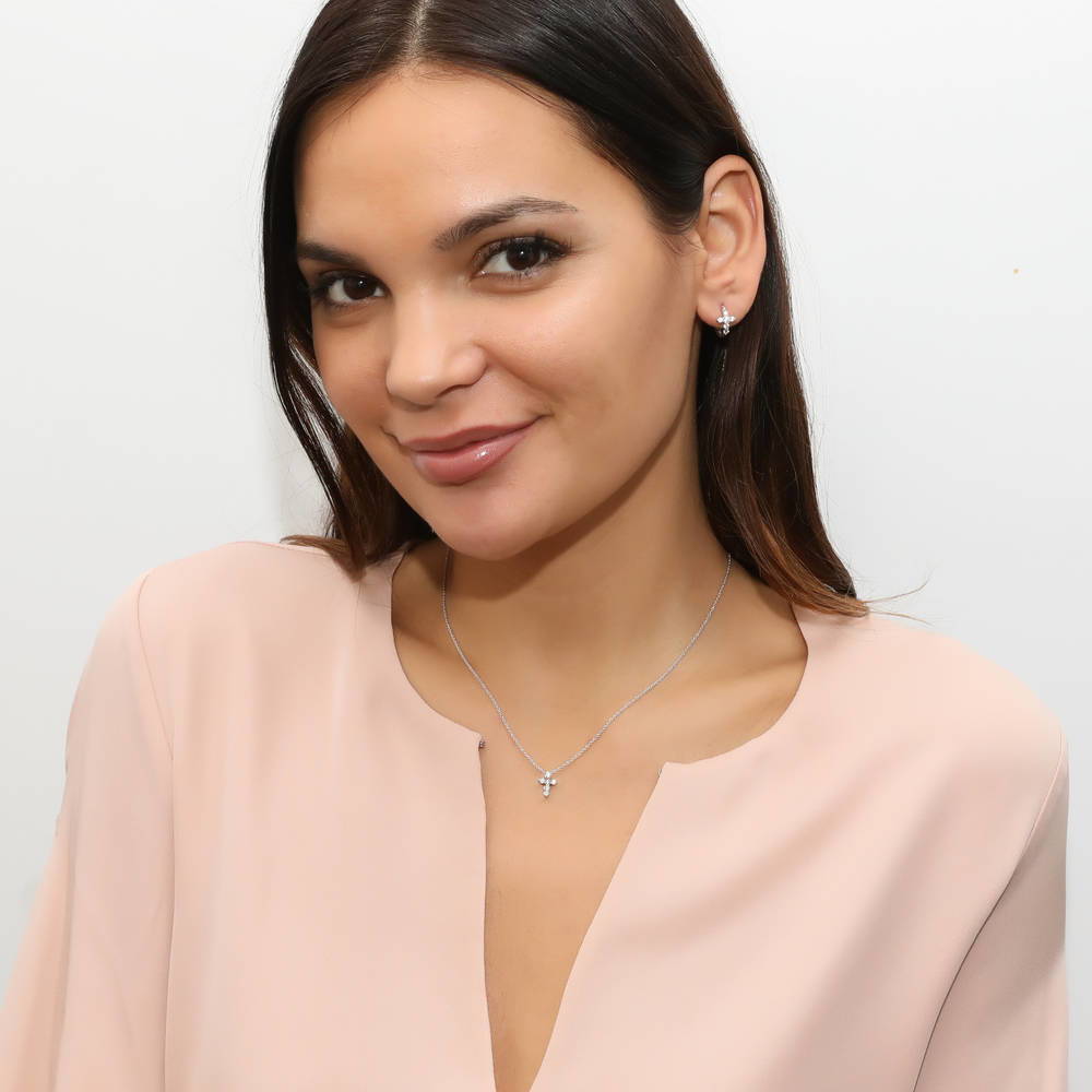 Model wearing Cross CZ Mini Huggie Earrings in Sterling Silver 0.5 inch, Rhodium Plated