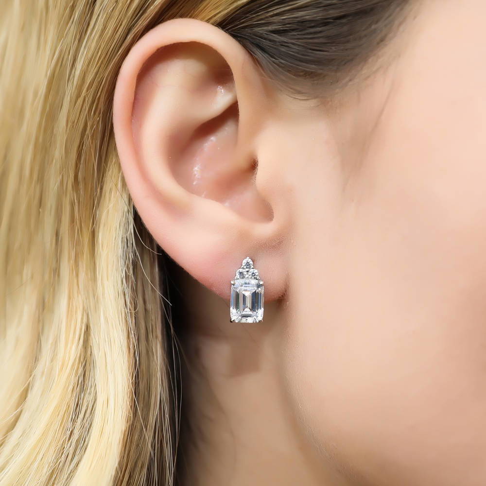 Model wearing Solitaire 4.2ct Emerald Cut CZ Stud Earrings in Sterling Silver, 5 of 8