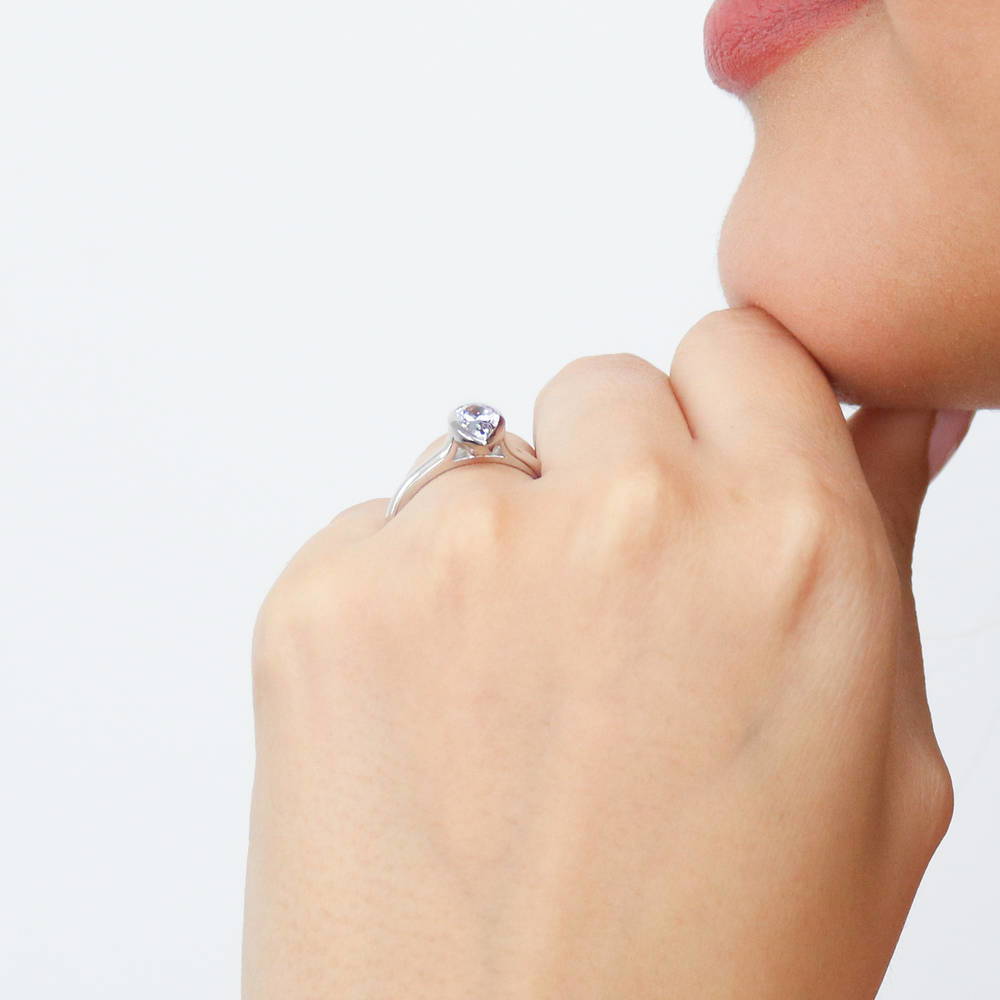 Model wearing Solitaire 0.8ct Bezel Set Pear CZ Ring in Sterling Silver, 3 of 8