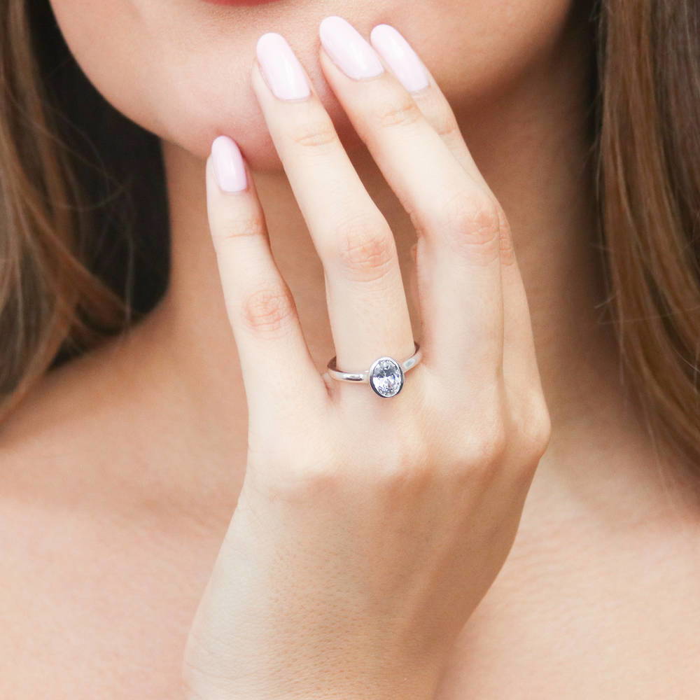 Model wearing Solitaire 1.2ct Bezel Oval CZ Ring in Sterling Silver, 2 of 8