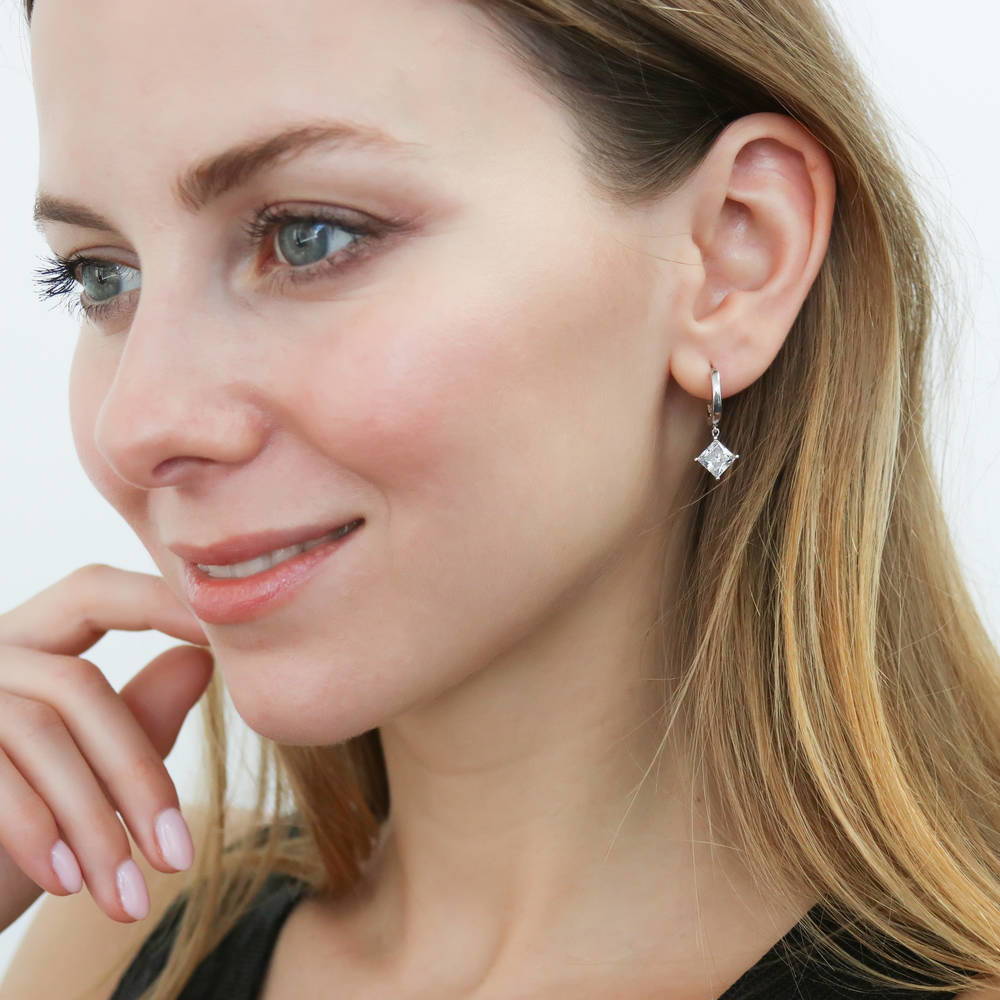 Model wearing Solitaire 2.4ct Princess CZ Dangle Earrings in Sterling Silver, 2 of 3