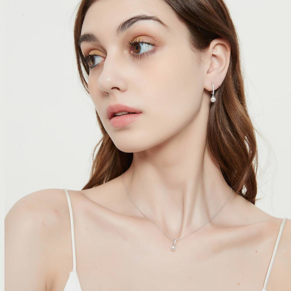 Model wearing Solitaire White Round Imitation Pearl Earrings in Sterling Silver, 3 of 4