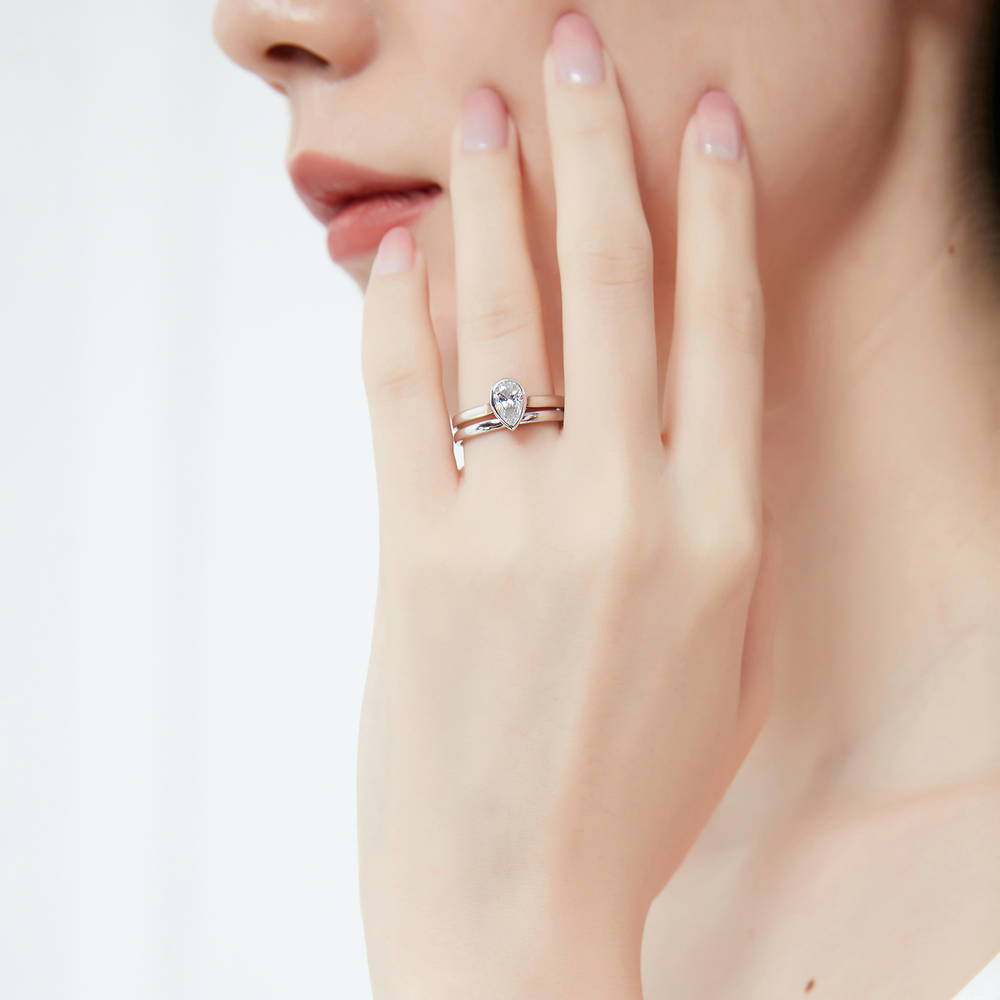 Model wearing Solitaire 0.8ct Bezel Set Pear CZ Ring Set in Sterling Silver, 2 of 13