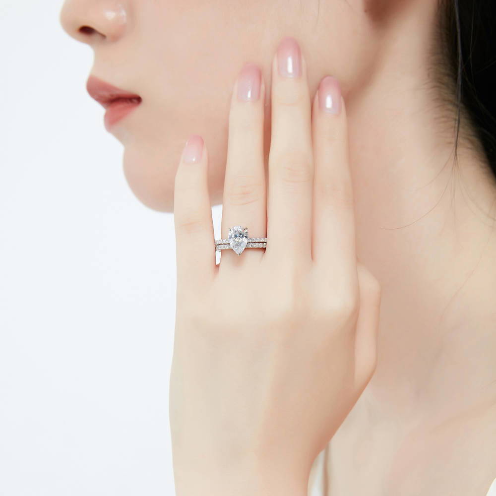 Model wearing Solitaire Hidden Halo 1.8ct Pear CZ Ring Set in Sterling Silver, 2 of 13