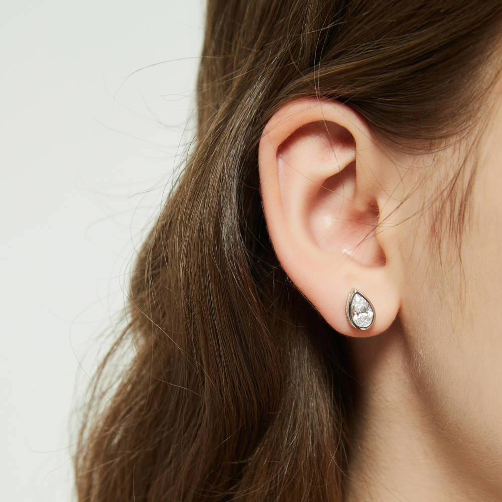 Model wearing Solitaire 1.6ct Bezel Pear CZ Stud Earrings in Sterling Silver, 5 of 7