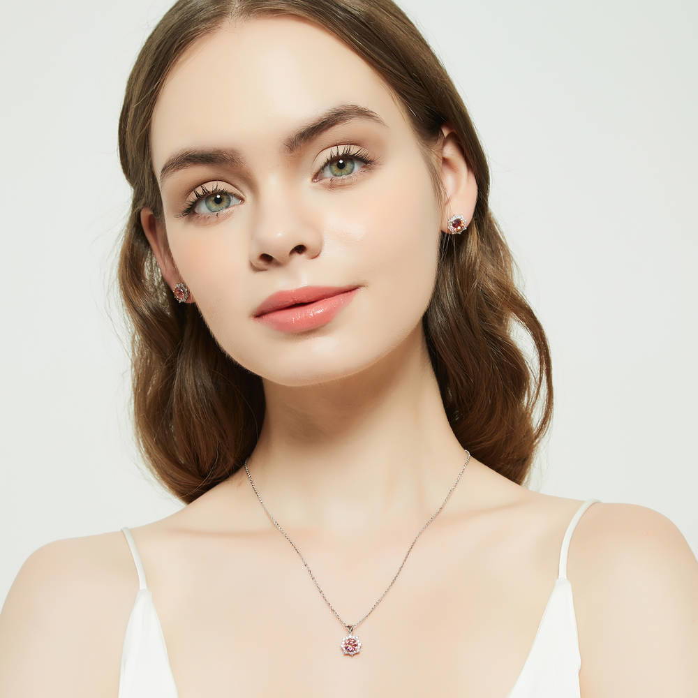 Model wearing Sunburst Halo CZ Stud Earrings in Sterling Silver, Red Orange Color