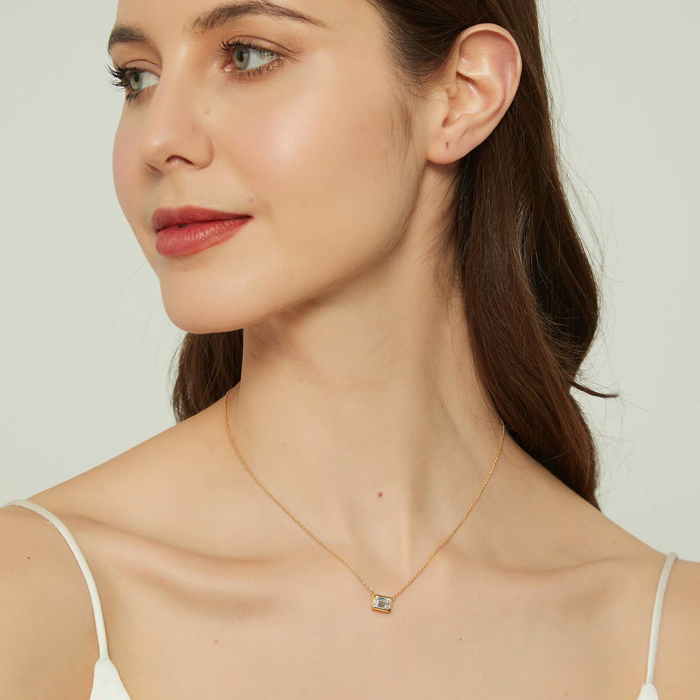 Model wearing Solitaire 1ct Bezel Set Emerald Cut CZ Necklace in Sterling Silver, 3 of 9