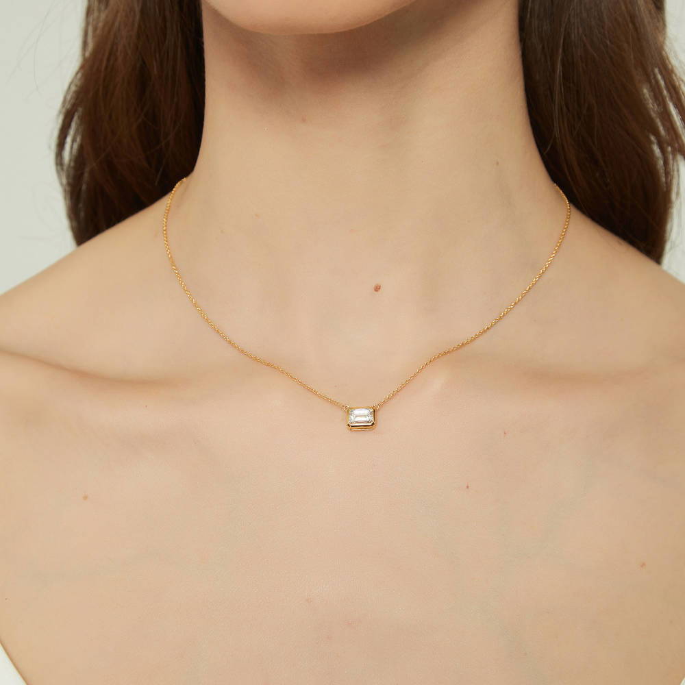 Model wearing Solitaire 1ct Bezel Set Emerald Cut CZ Necklace in Sterling Silver, 2 of 9