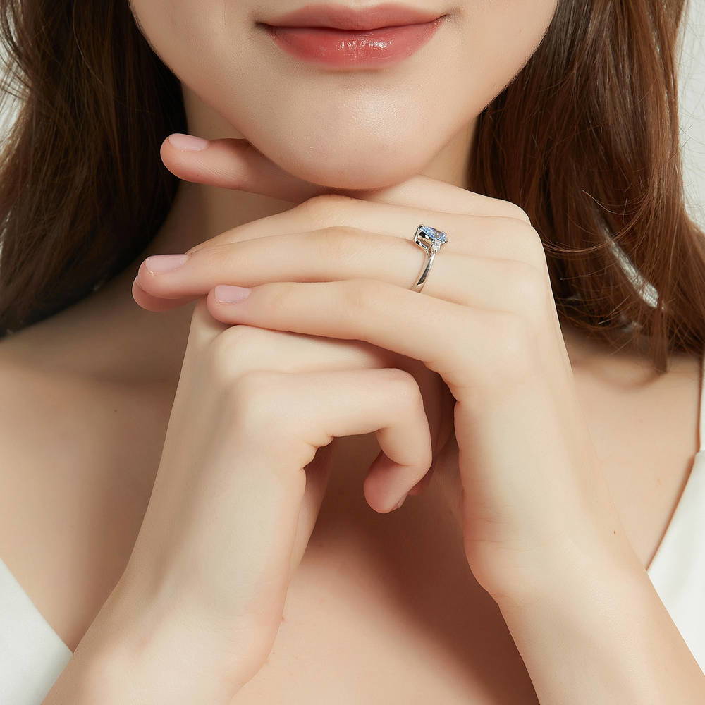 Model wearing 3-Stone Greyish Blue Pear CZ Ring in Sterling Silver, 6 of 9