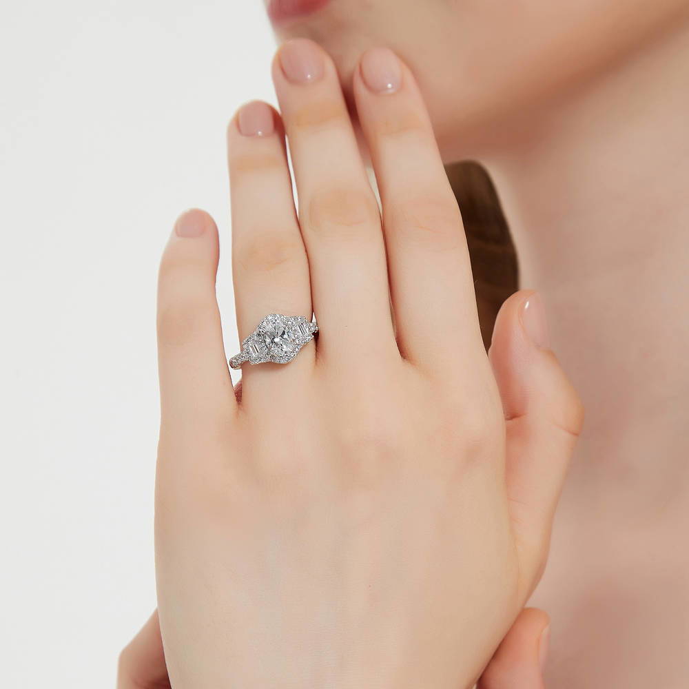Model wearing 3-Stone Halo Art Deco 1.2ct Oval CZ Ring in Sterling Silver, 2 of 11