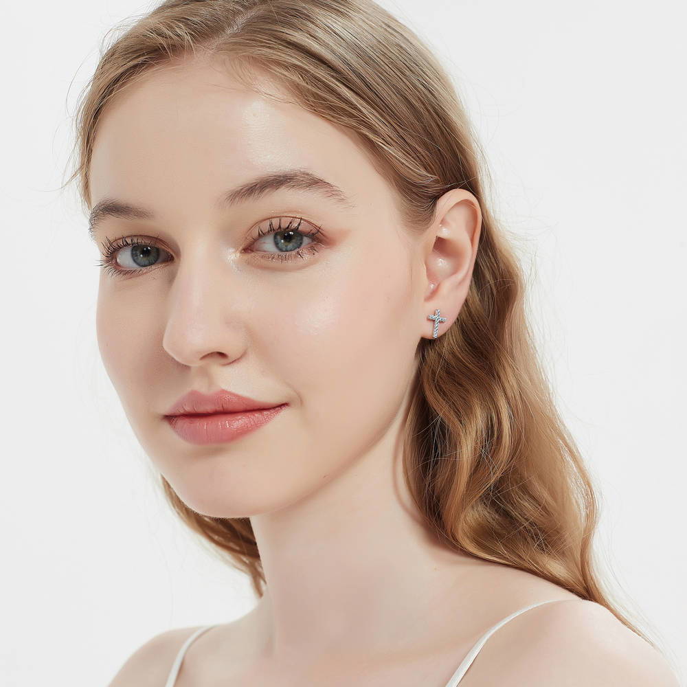 Model wearing Cross CZ Stud Earrings in Sterling Silver, Greyish Blue Color
