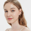 Model wearing Cross CZ Stud Earrings in Sterling Silver, Greyish Blue Color