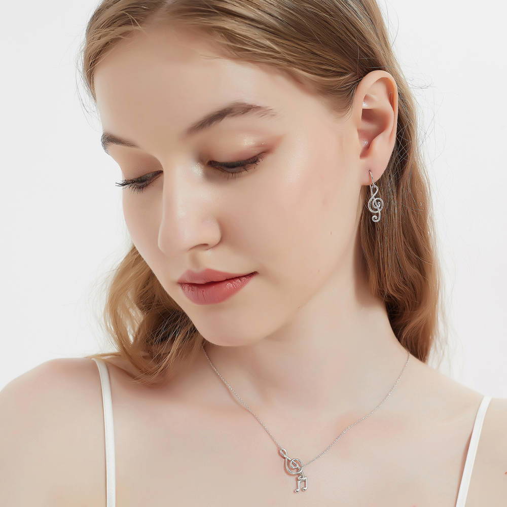 Model wearing Treble Clef Music Note Necklace and Earrings Set in Sterling Silver, 2 of 14