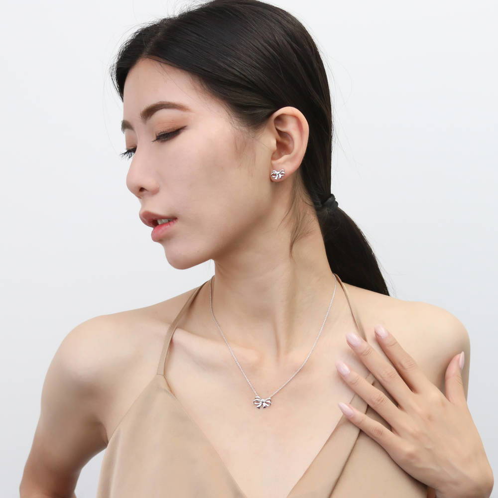 Model wearing Bow Tie Ribbon CZ Necklace in Sterling Silver, Style 1