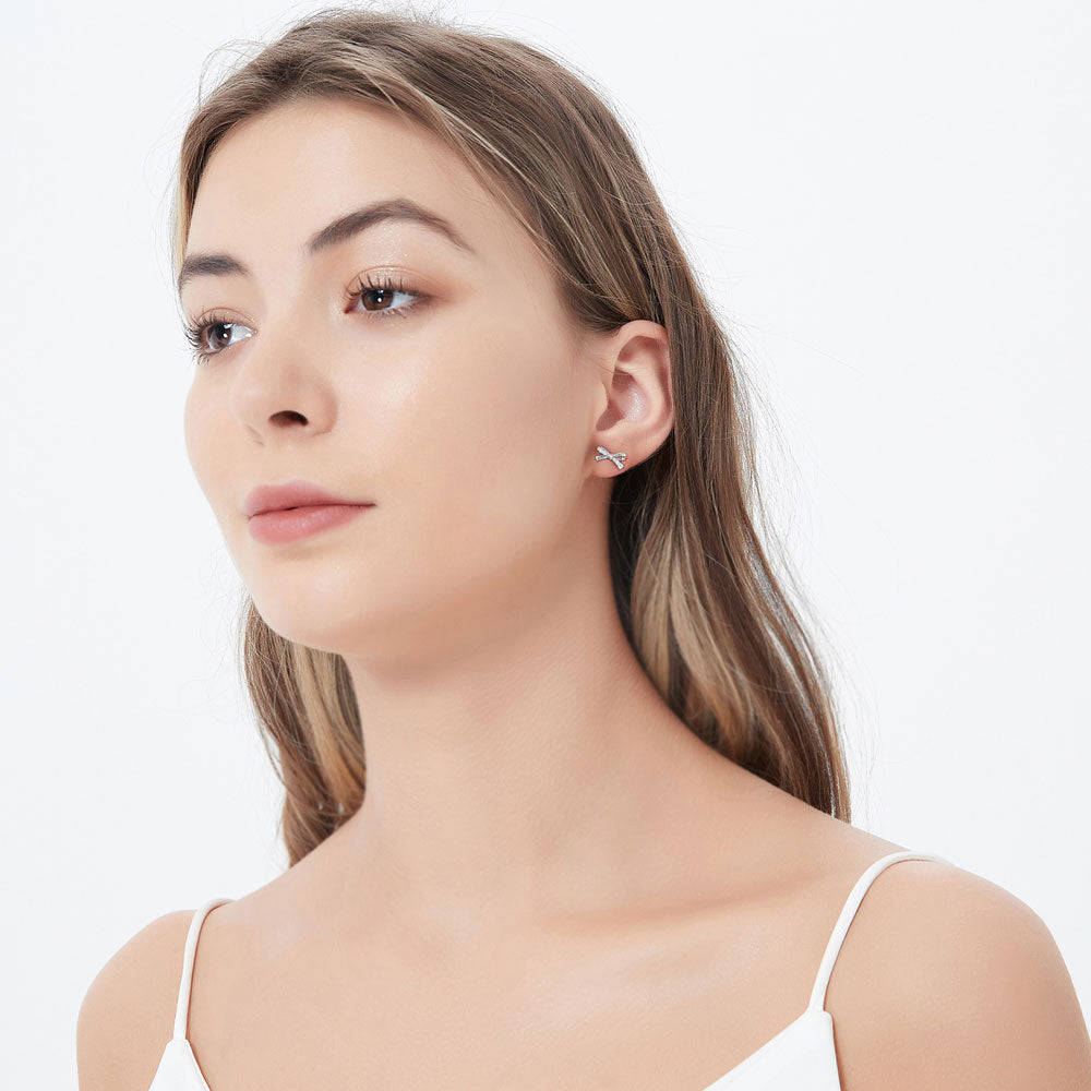 Model wearing Bow Tie Ribbon CZ Stud Earrings in Sterling Silver, 3 of 6