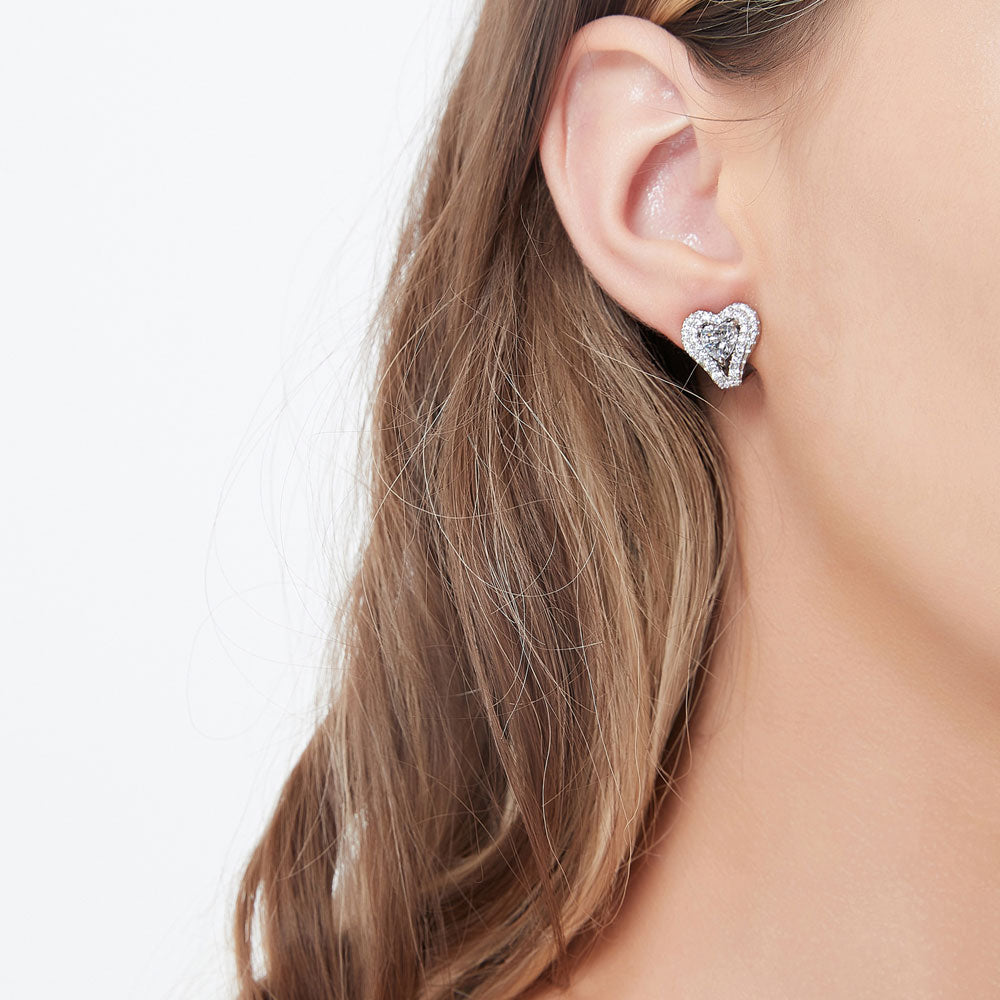 Model wearing Heart Halo CZ Omega Back Stud Earrings in Sterling Silver, 2 of 5