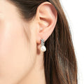Model wearing Solitaire Baroque Cultured Pearl Stud Earrings in Sterling Silver, Yellow Gold Flashed