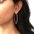 Model wearing CZ Large Inside-Out Hoop Earrings in Sterling Silver 2 inch, Yellow Gold Flashed