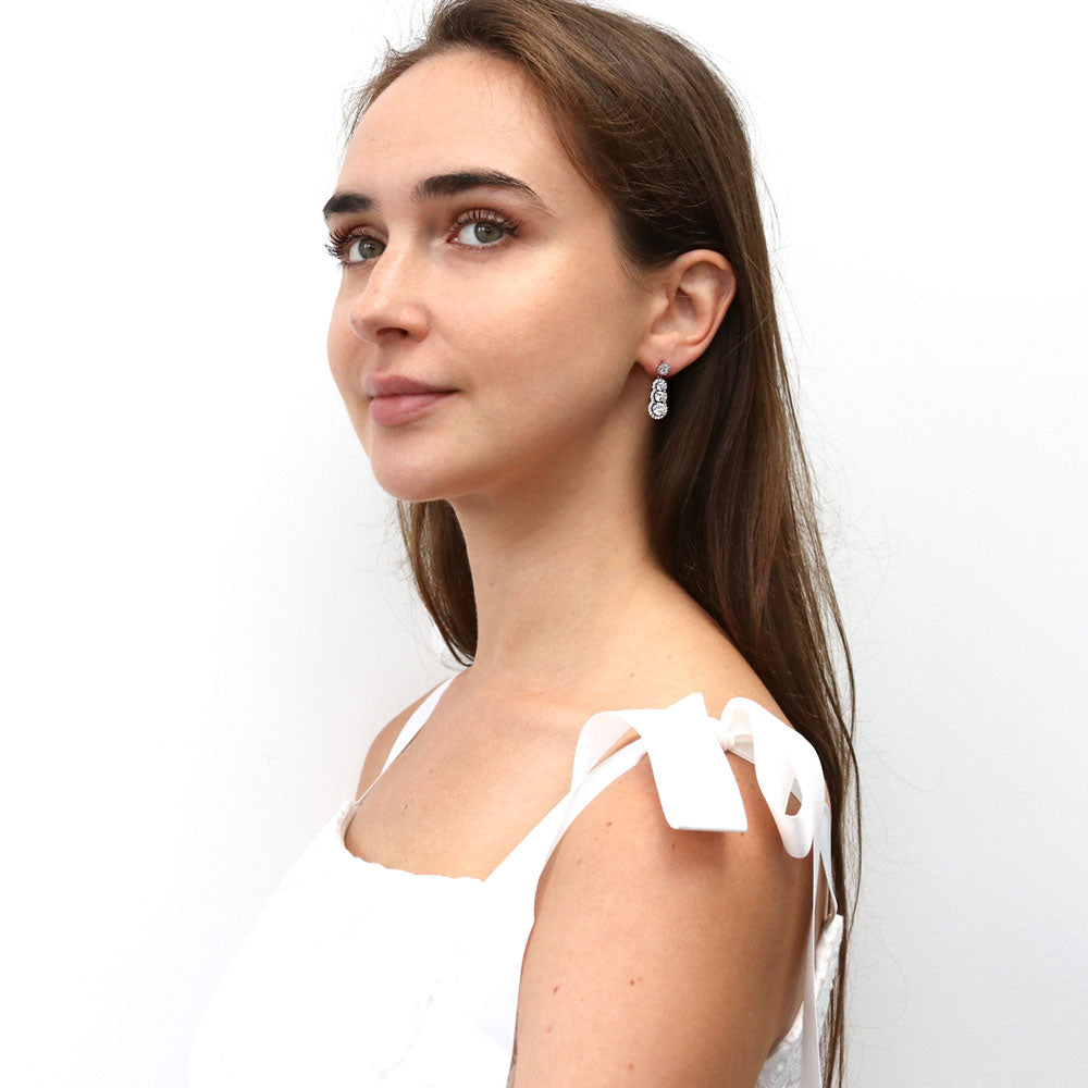 Model wearing Graduated Halo CZ Earrings in Sterling Silver, 3 of 7