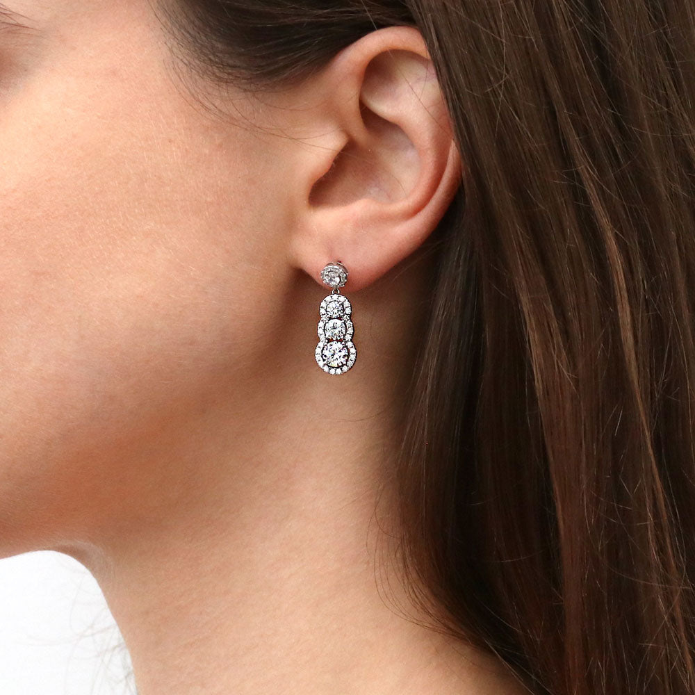 Model wearing Graduated Halo CZ Earrings in Sterling Silver, 2 of 7