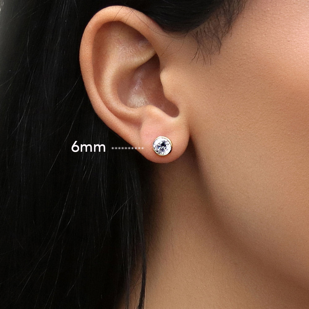 Model wearing Solitaire Bezel Set Round CZ Stud Earrings in Sterling Silver, 9 of 20