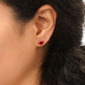 Model wearing Solitaire 1.6ct CZ Cartilage Stud Earrings in Sterling Silver, Garnet Color