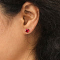 Model wearing Solitaire 1.6ct CZ Cartilage Stud Earrings in Sterling Silver, Ruby Color