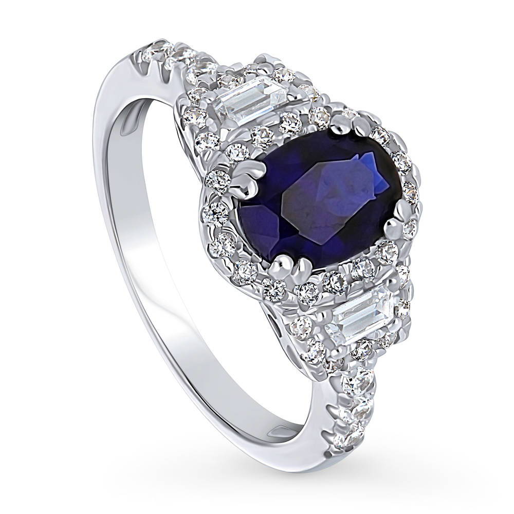 Front view of 3-Stone Halo Simulated Blue Sapphire Oval CZ Ring in Sterling Silver, 4 of 10